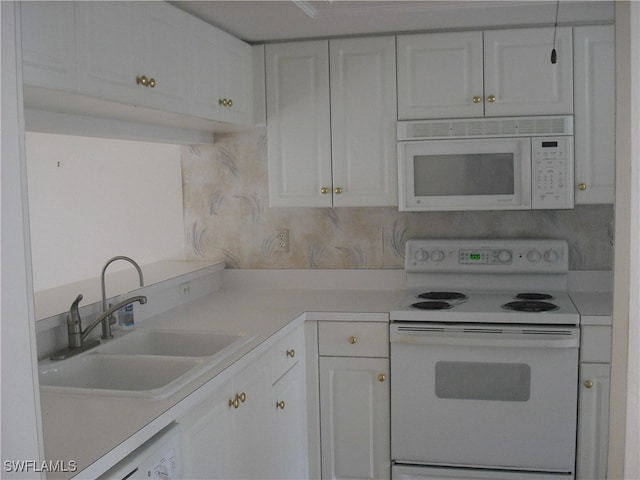 kitchen featuring washer / clothes dryer, white appliances, sink, and white cabinets