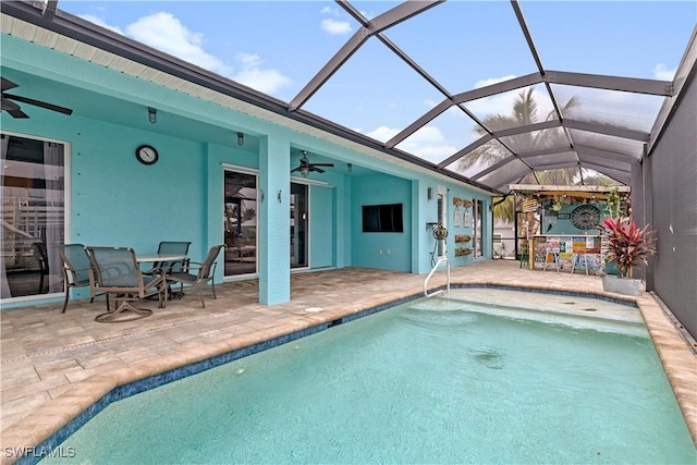 view of swimming pool with ceiling fan, a lanai, and a patio area