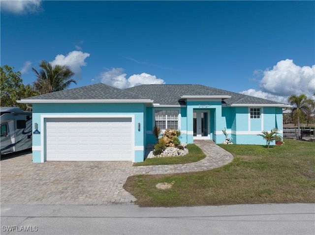 single story home featuring a garage and a front yard