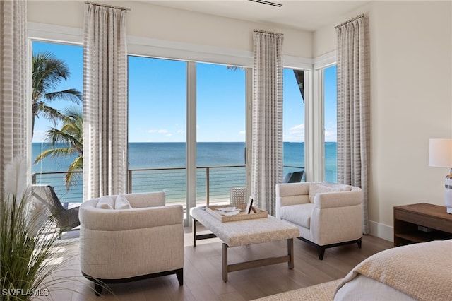 bedroom featuring multiple windows, wood-type flooring, and a water view