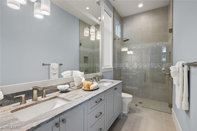 bathroom with vanity, toilet, tile patterned floors, and a shower with shower door