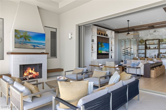 living room featuring a tiled fireplace and built in features