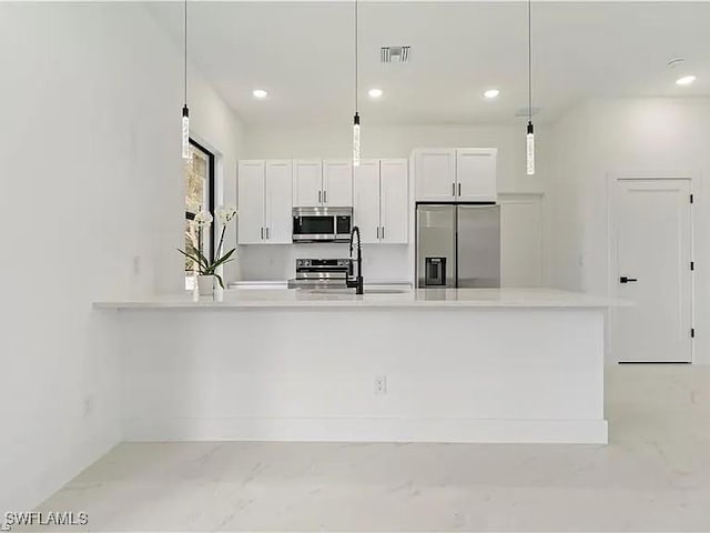 kitchen featuring white cabinets, stainless steel appliances, hanging light fixtures, and sink