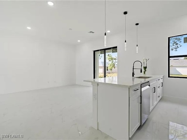 kitchen with a kitchen island with sink, sink, dishwasher, white cabinetry, and hanging light fixtures