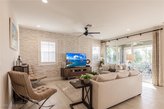 living room featuring light wood-type flooring, ceiling fan, and plenty of natural light