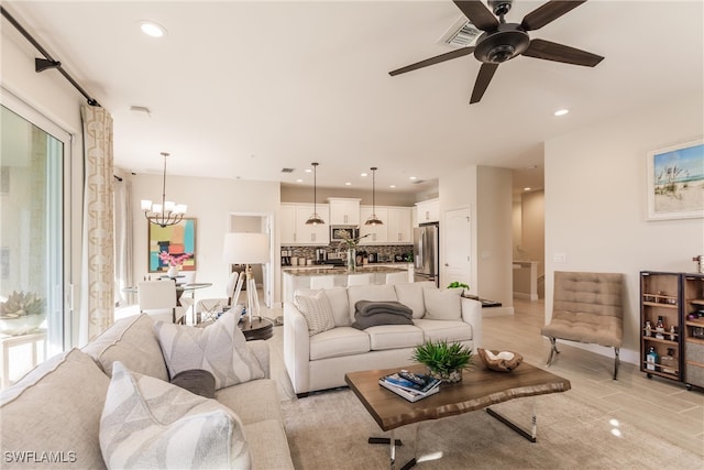 living room featuring ceiling fan with notable chandelier