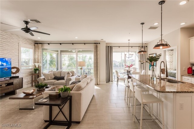 living room with light tile patterned flooring, ceiling fan, and sink