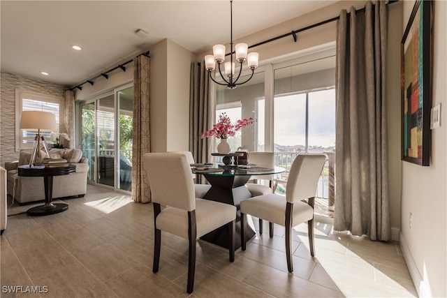 dining space with light tile patterned floors and an inviting chandelier