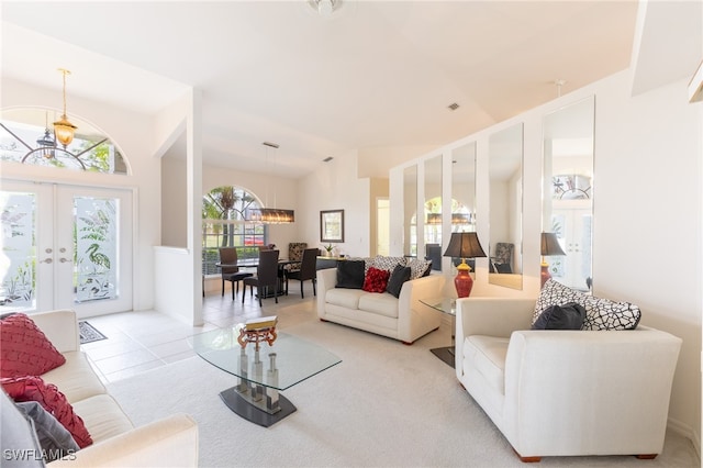 living room with french doors, lofted ceiling, and light tile patterned flooring