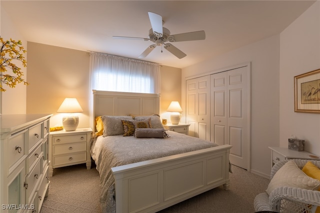 carpeted bedroom with ceiling fan and a closet