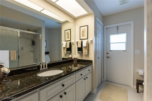 bathroom featuring vanity, a shower with shower door, and tile patterned floors