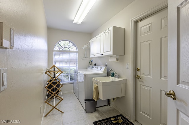 washroom featuring cabinets, light tile patterned floors, sink, and independent washer and dryer