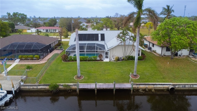 rear view of house featuring a water view, a lawn, a lanai, and a pool