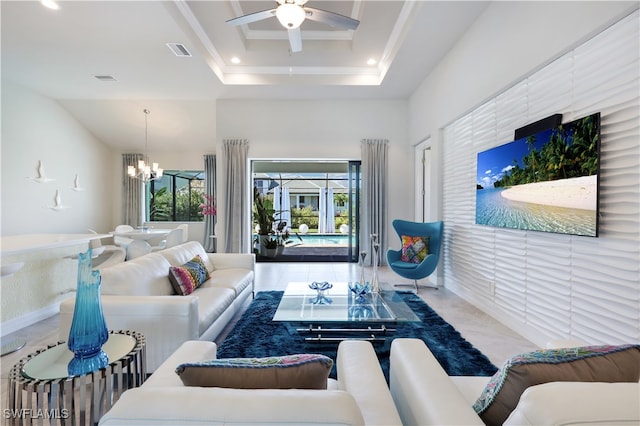 living room with a raised ceiling, crown molding, tile patterned floors, and ceiling fan with notable chandelier