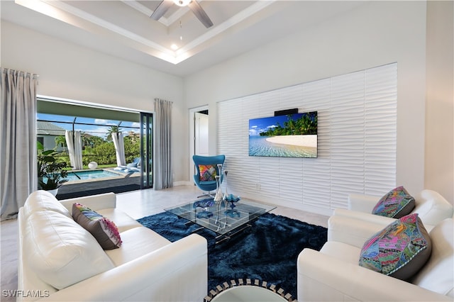 tiled living room with a raised ceiling and ceiling fan