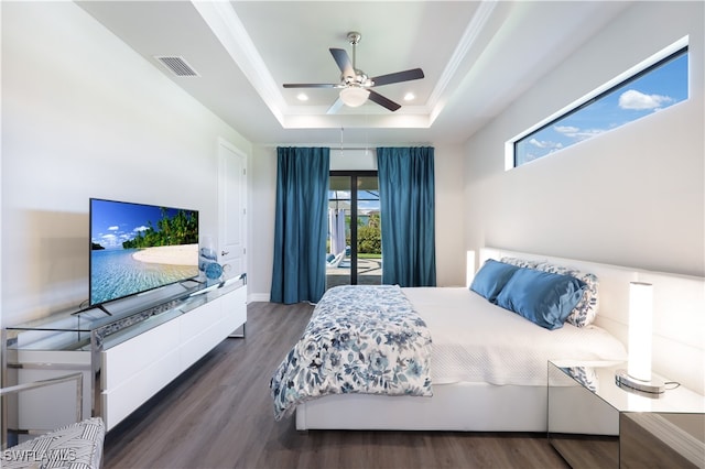 bedroom featuring access to exterior, ceiling fan, dark wood-type flooring, a raised ceiling, and ornamental molding