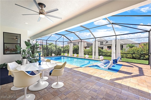 view of pool featuring ceiling fan, a patio area, and a lanai