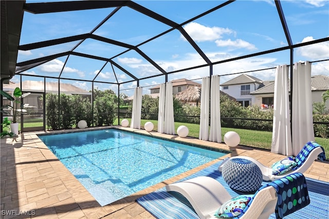 view of swimming pool featuring glass enclosure and a patio area