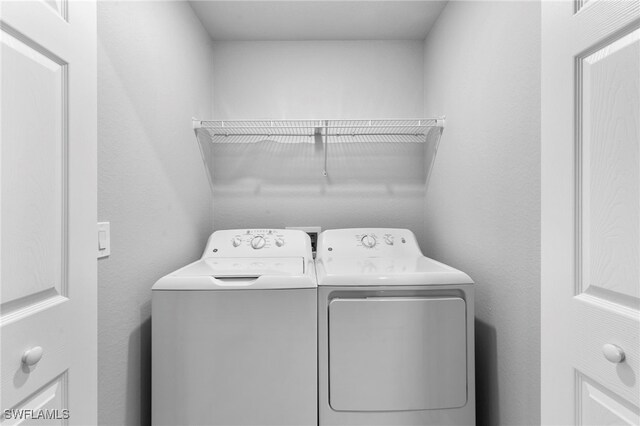 clothes washing area featuring separate washer and dryer