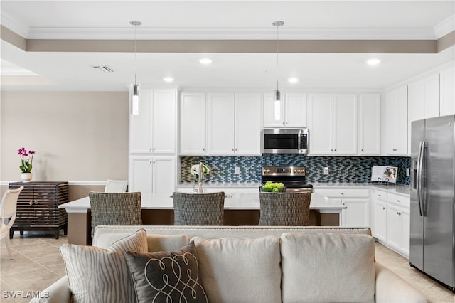 kitchen featuring stainless steel appliances, hanging light fixtures, a kitchen island with sink, backsplash, and white cabinetry