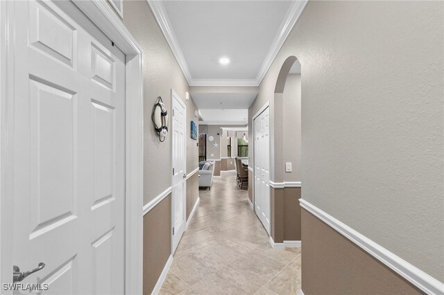 hallway featuring light tile patterned floors and ornamental molding