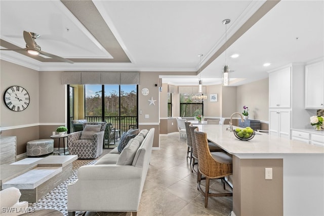 living room with ceiling fan, light tile patterned floors, and ornamental molding