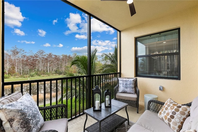 sunroom / solarium with ceiling fan and a water view