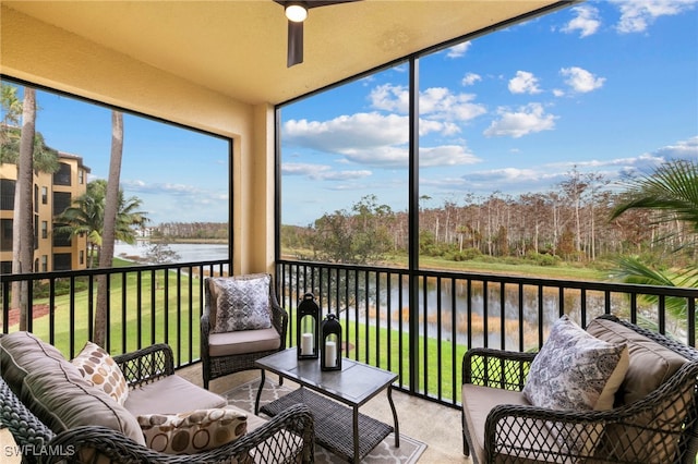 sunroom featuring a water view and ceiling fan