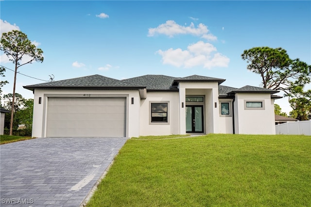 prairie-style home with a garage and a front lawn