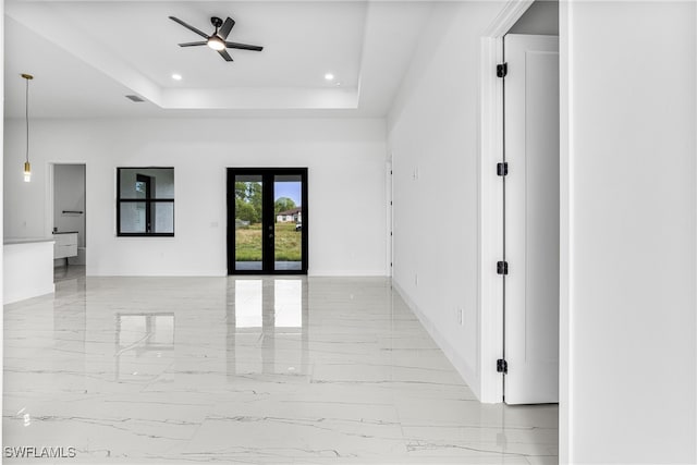 unfurnished room featuring a tray ceiling, french doors, and ceiling fan