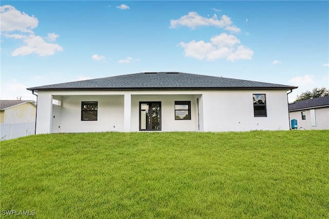 rear view of house featuring a yard