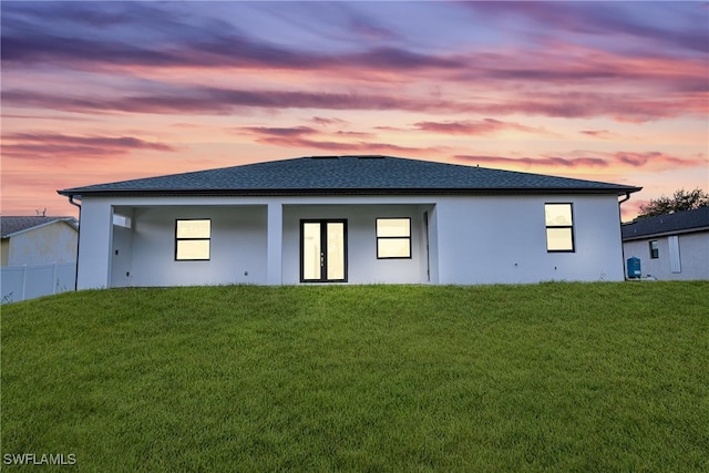 back house at dusk with a yard