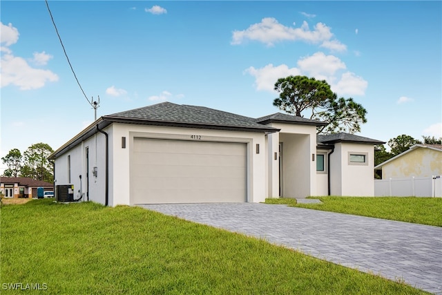 prairie-style house with a front lawn, central air condition unit, and a garage