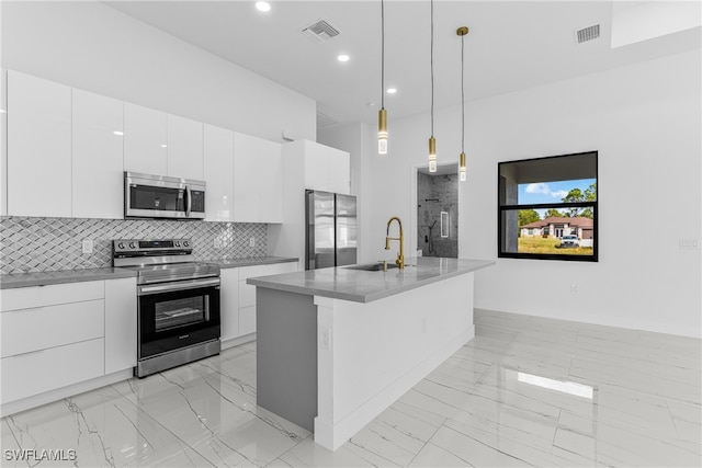 kitchen with stainless steel appliances, sink, decorative light fixtures, a kitchen island with sink, and white cabinets