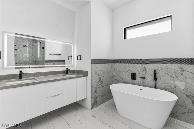 bathroom featuring tile walls, a bathtub, and vanity