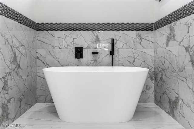 bathroom with tile walls and a bathtub