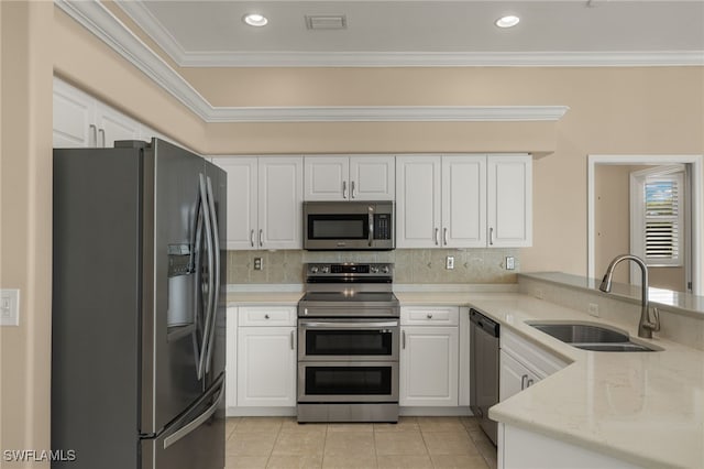 kitchen featuring appliances with stainless steel finishes, white cabinets, a sink, a peninsula, and light tile patterned flooring