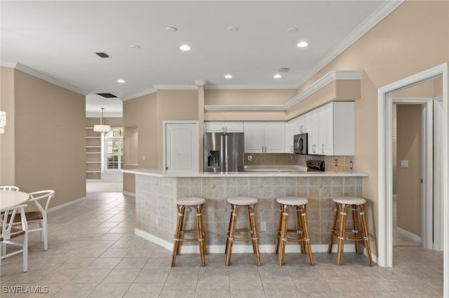 kitchen featuring white cabinets, kitchen peninsula, stainless steel appliances, and light tile patterned floors