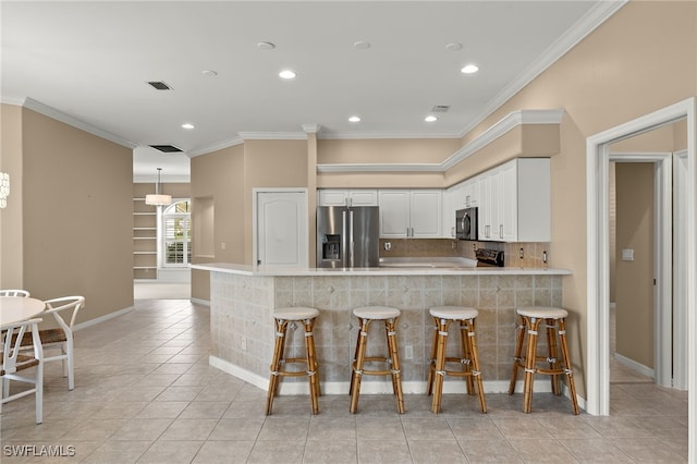 kitchen with ornamental molding, recessed lighting, a peninsula, and appliances with stainless steel finishes