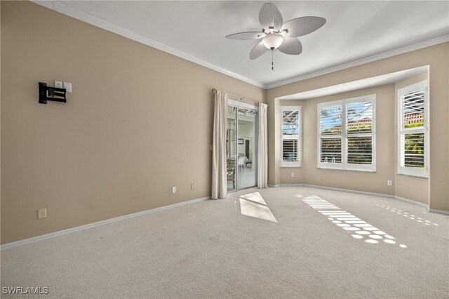 unfurnished room with ornamental molding, a ceiling fan, carpet flooring, and baseboards