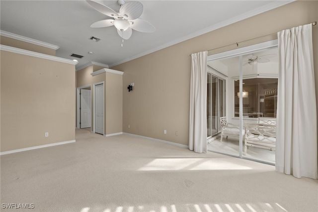 carpeted empty room with visible vents, a ceiling fan, ornamental molding, and baseboards