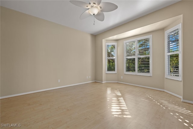 unfurnished room featuring light wood-style floors, a ceiling fan, and baseboards