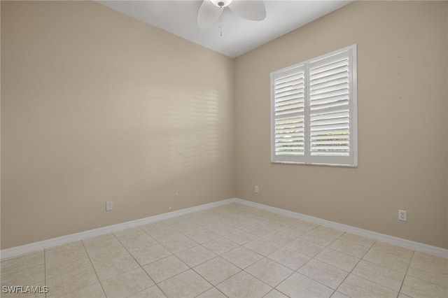 empty room featuring light tile patterned floors, ceiling fan, and baseboards