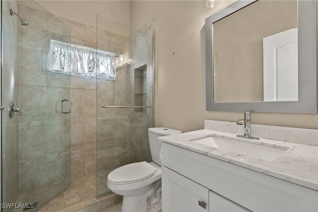 full bathroom featuring a stall shower, toilet, and vanity
