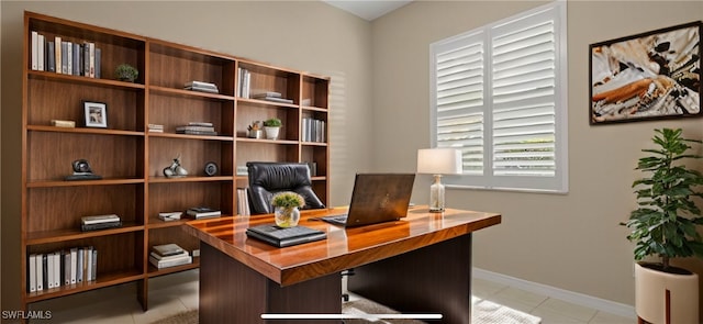 office space with baseboards and light tile patterned flooring