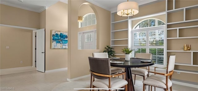 dining area featuring baseboards, a high ceiling, and crown molding