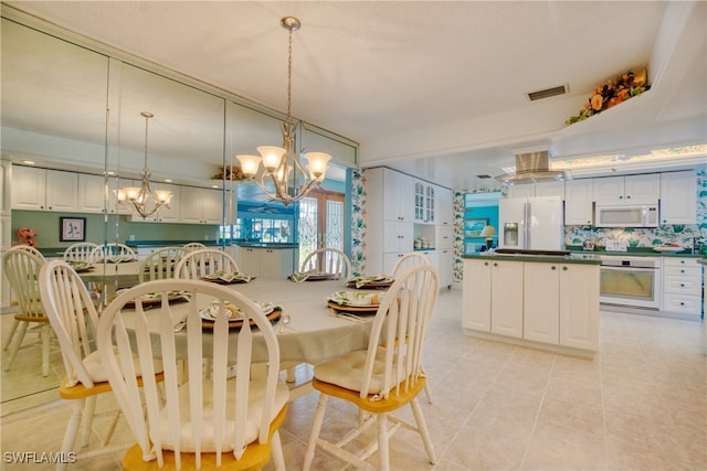 tiled dining space featuring a chandelier