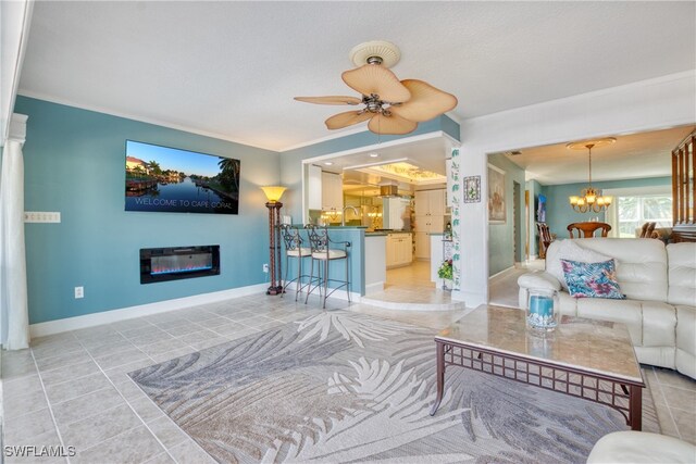 tiled living room with ceiling fan with notable chandelier and crown molding