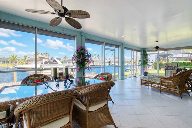 sunroom featuring a water view