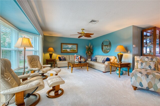 carpeted living room featuring a textured ceiling and ceiling fan